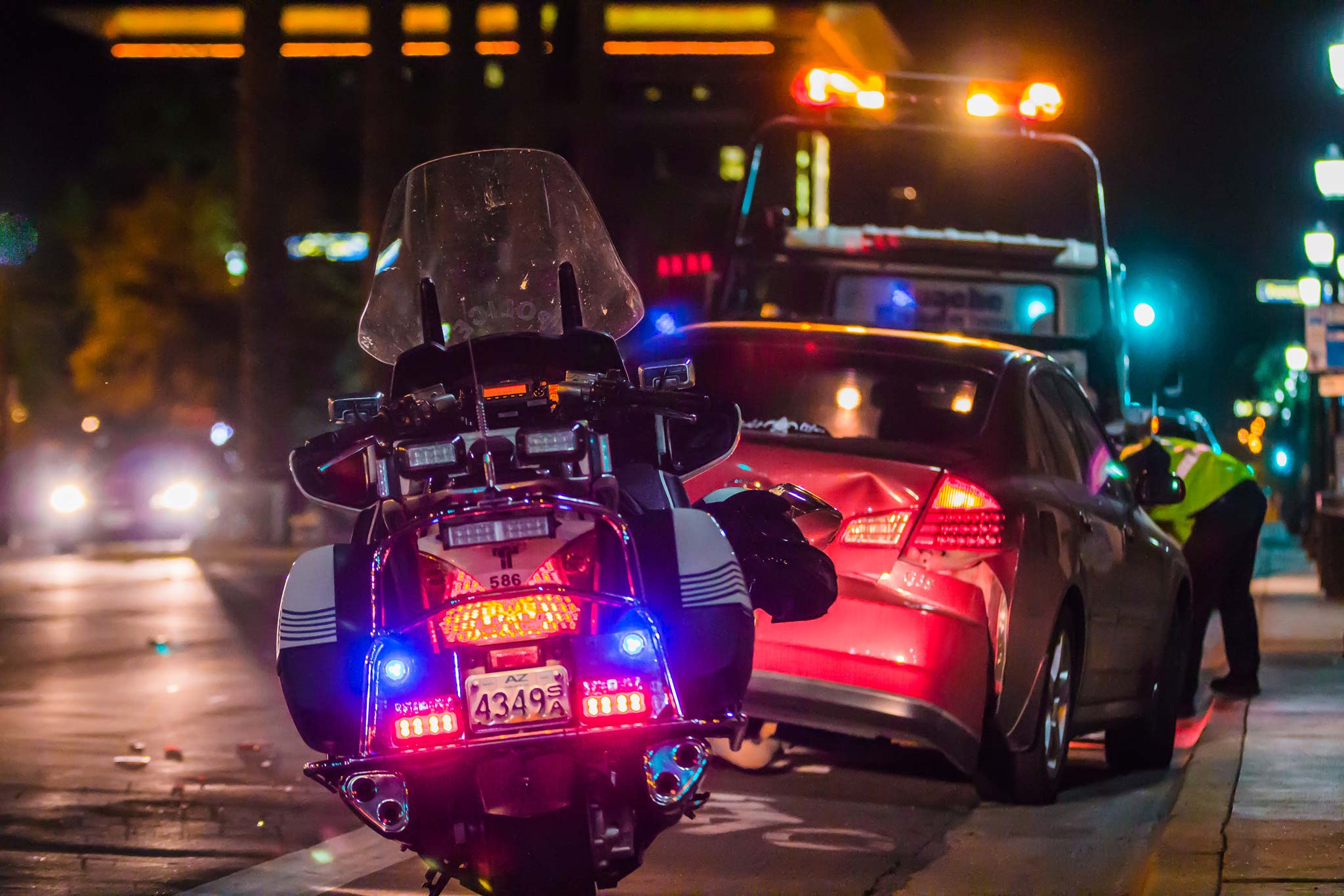 a police motorcycle views from behind at a traffic accident at night.