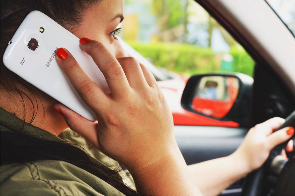 a distracted driver on a cell phone while driving in a car.