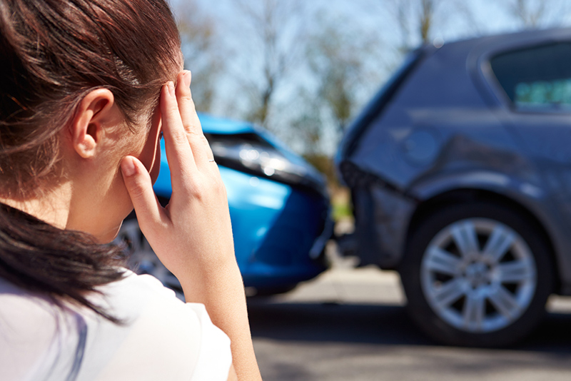 a woman touching her forehead after a car accident